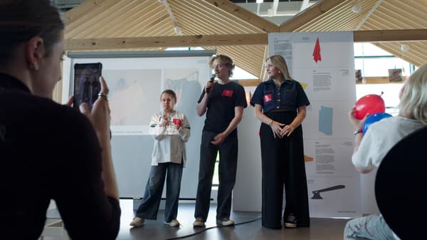 2 studenten presenteren samen met het betrokken kind hun ontwerp aan het grote publiek