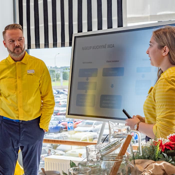 2 zaměstnanci co plánují IKEA kuchyně u flip chartu