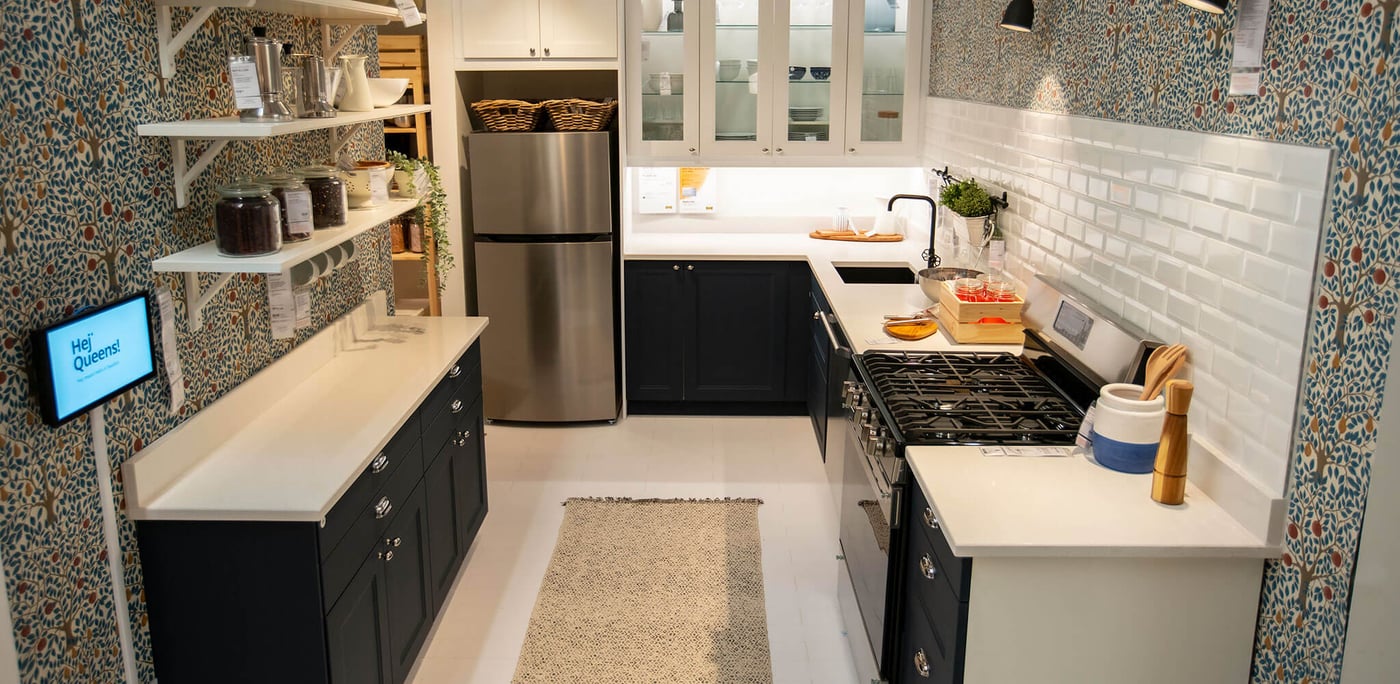 A kitchen display featuring a dark kitchen cabinet front with white countertops and lighting above, linking to News article.