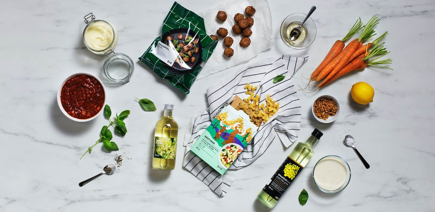 An assortment of plant based ingredients arranged around a package of plant balls and a bottle of cooking oil.