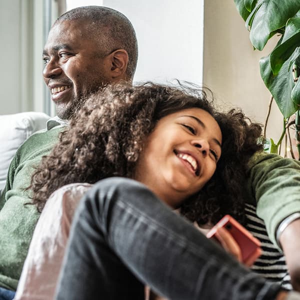 A smiling middle aged man sitting with his daughter