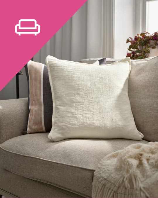 3 cojines en tonos tierra y beige sobre un sofá IKEA.