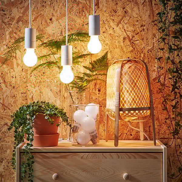 3 IKEA LED light bulbs hanging over a wooden chest of drawers