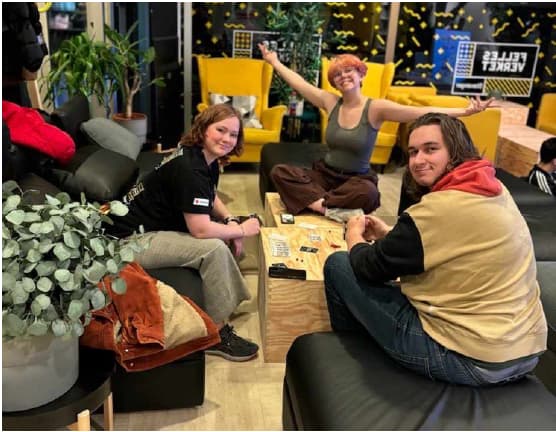 3 som sitter og ser på kameraet og smiler.