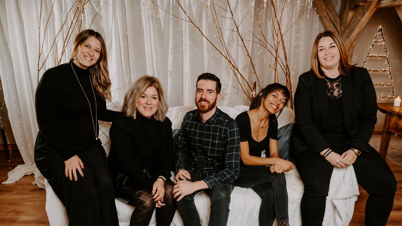 4 femmes et 1 hommes assis sur un canapé blanc