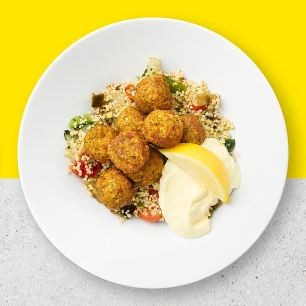8 Falafel balls with couscous and vegetables with aioli sauce and lemon.