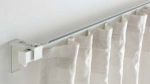 A 1-track silver VIDGA curtain track mounted on a wall. There's a curtain on it.