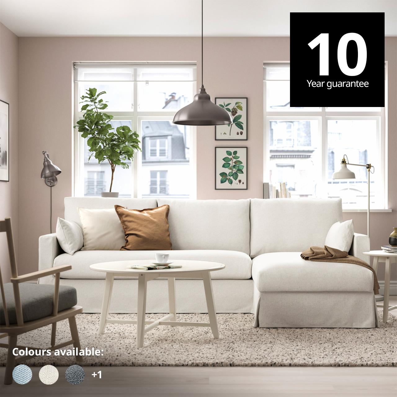 A 3-seater HYLTARP sofa in gransel natural colour placed next to the window in the living room with a plush VOLLERSLEV rug. A 10-year guarantee tag is placed over the image at the top right corner. White text overlay image that reads "Colours available:" with the colour swatch of Hallarp beige, Hallarp grey and Saxemara black-blue.