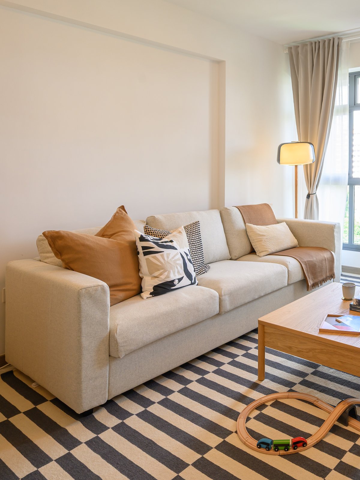 A 45 degree angle shot of homeowner's living room showcasing a gunnared beige 3-seat VIMLE sofa.