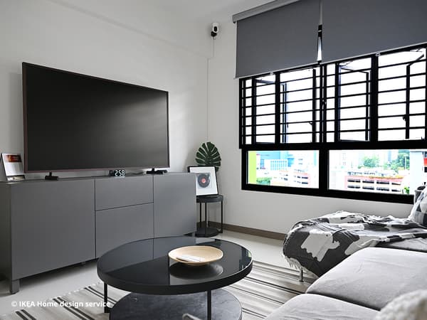 A 45 degree angle shot of the homeowner's living room showcasing a BESTÅ storage combination with door in Stubbarp dark grey as a TV console, FRÖTORP coffee table in antracite marble effect and a fridtuna dark grey SÖDERHAMN sofa. 