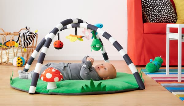 A baby playing with the baby gym from the KLAPPA toys collection.