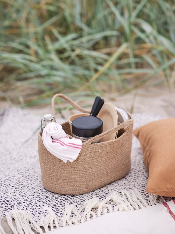 A basket sitting outside next to grass.