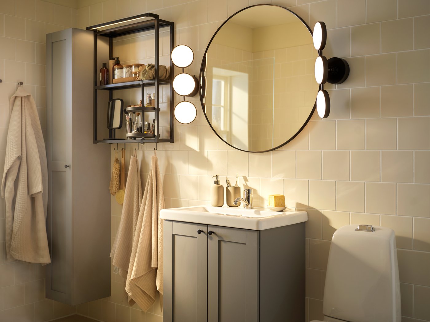A bathroom with a LINDBYN mirror in black, VÅGSJÖN hand towels and a BJÄLVEN bath robe hanging, open and closed storage.