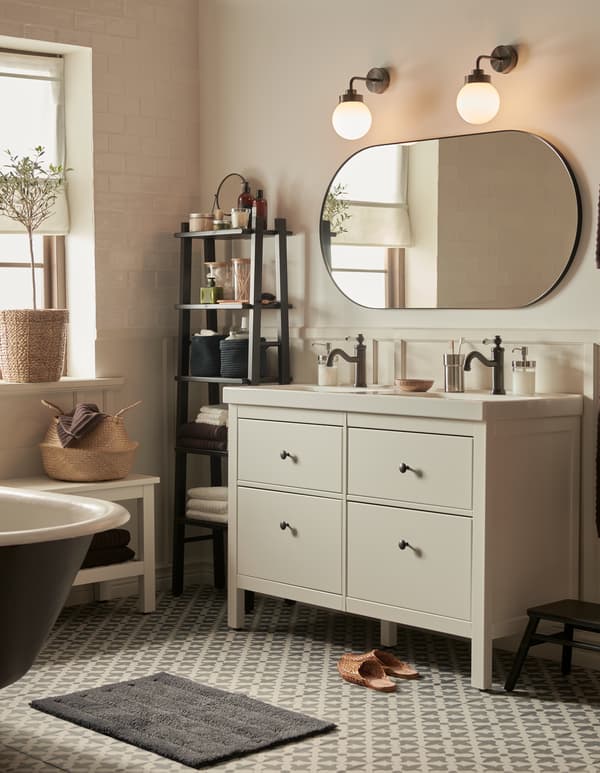 A bathroom with Moroccan style tiles and neutral colours, a HEMNES wash-stand with four drawers, and a large mirror.