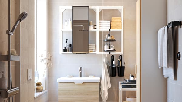 A bathroom with two ENHET wall frames with shelves in white, various ENHET bathroom furniture and other bathroom items.