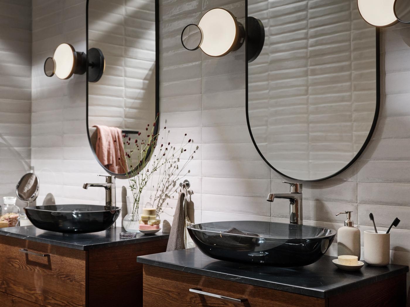 A bathroom with two OXMYREN countertop sink cabinets in dark gray glass, with two LINDBYN mirrors in black above.