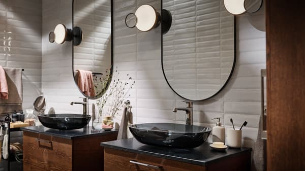 A bathroom with two OXMYREN countertop washbasins in dark grey glass, with two LINDBYN mirrors in black above.