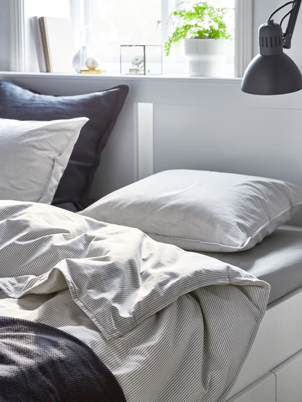 A bed dressed with soft cotton IKEA BERGPALM quilt covers and pillowcases.