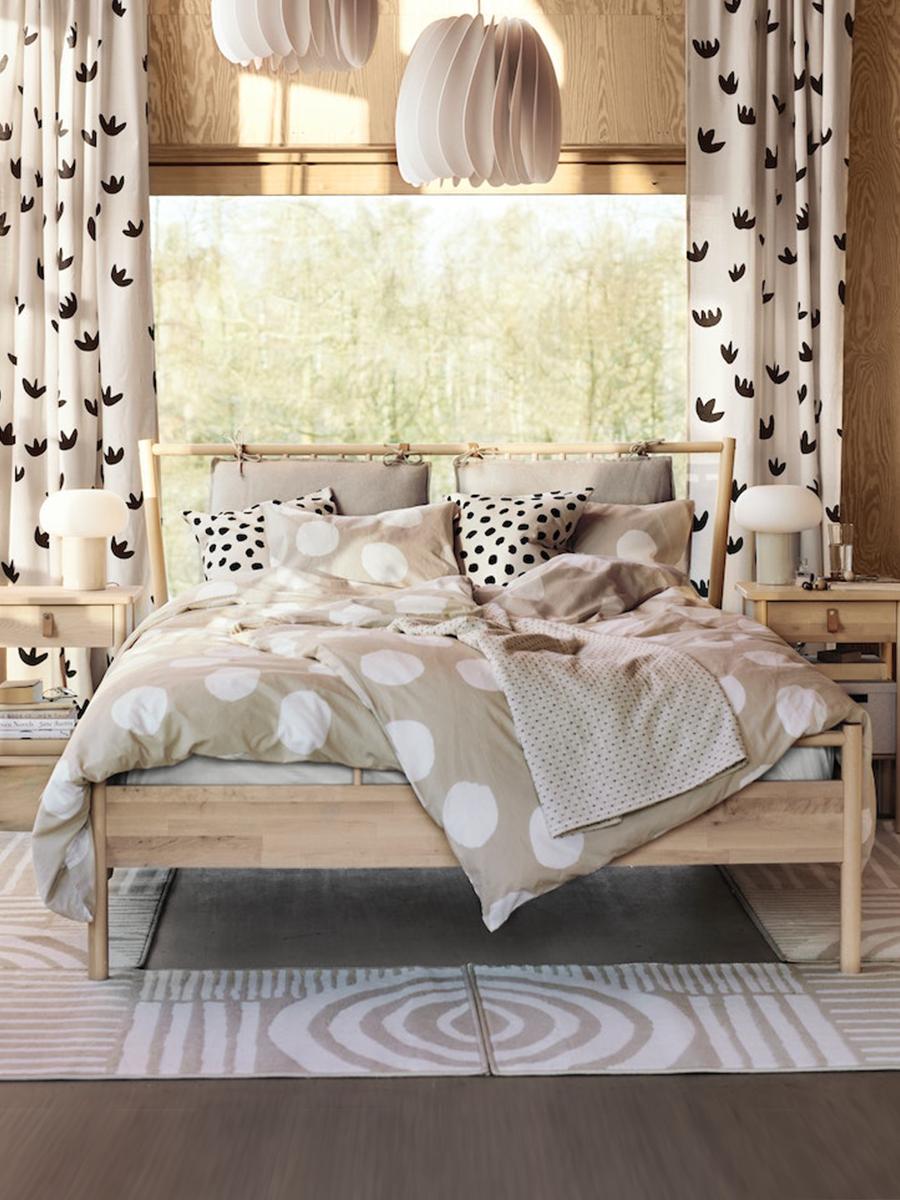 A bed is covered with the KLYNNETAG beige duvet cover and pillowcases with dotted patterns.