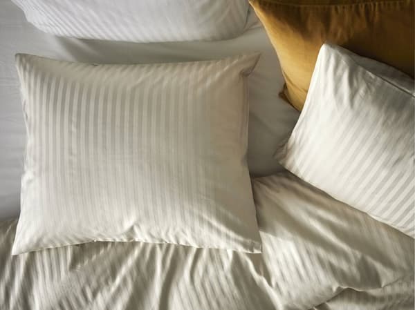 A bed made with IKEA NATTJASMIN bed linen in cotton.