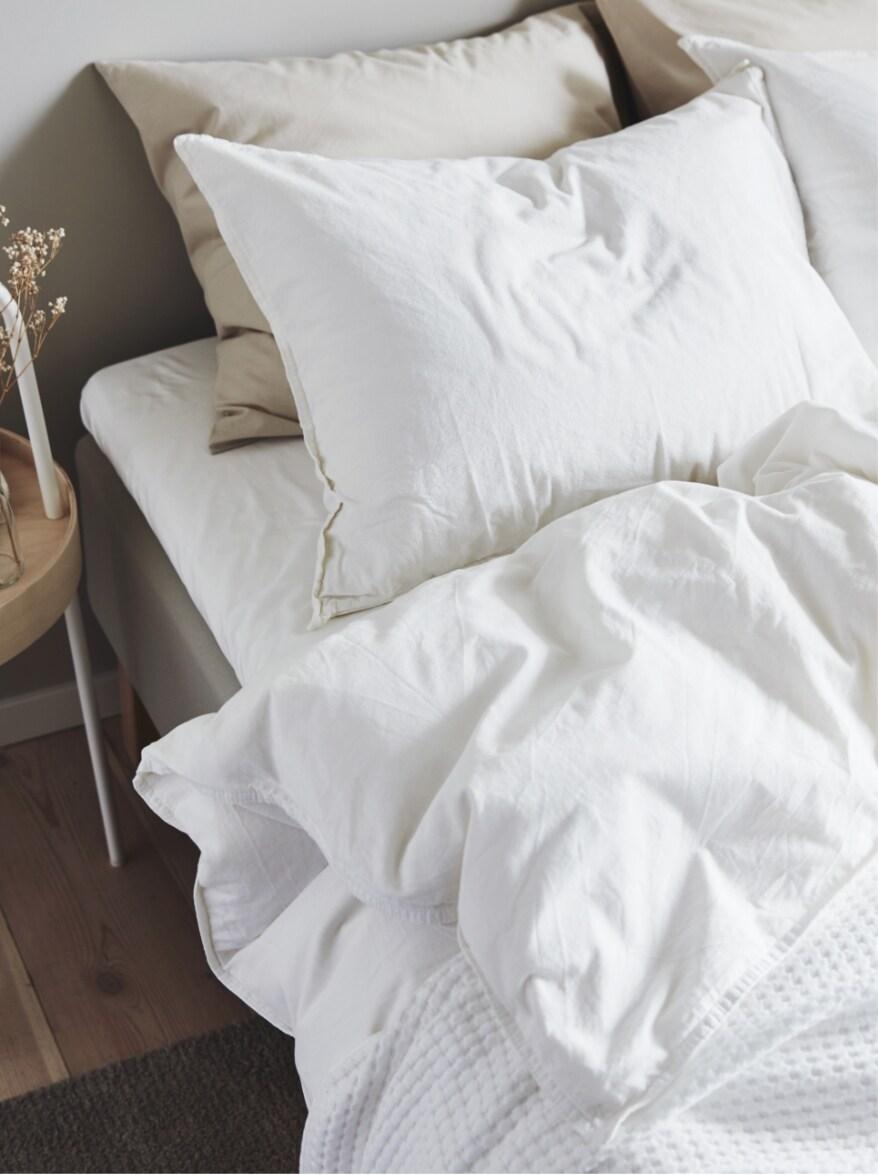 A bed with several pillows and blanket on it.