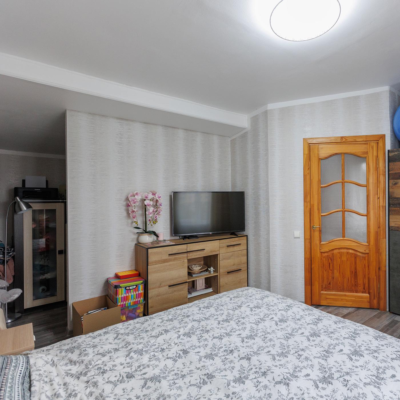 A bedroom before the makeover, featuring a large dark-coloured wardrobe with a blue exercise ball placed on top.