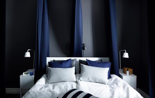 A bedroom interior with double bed in the center of it.
