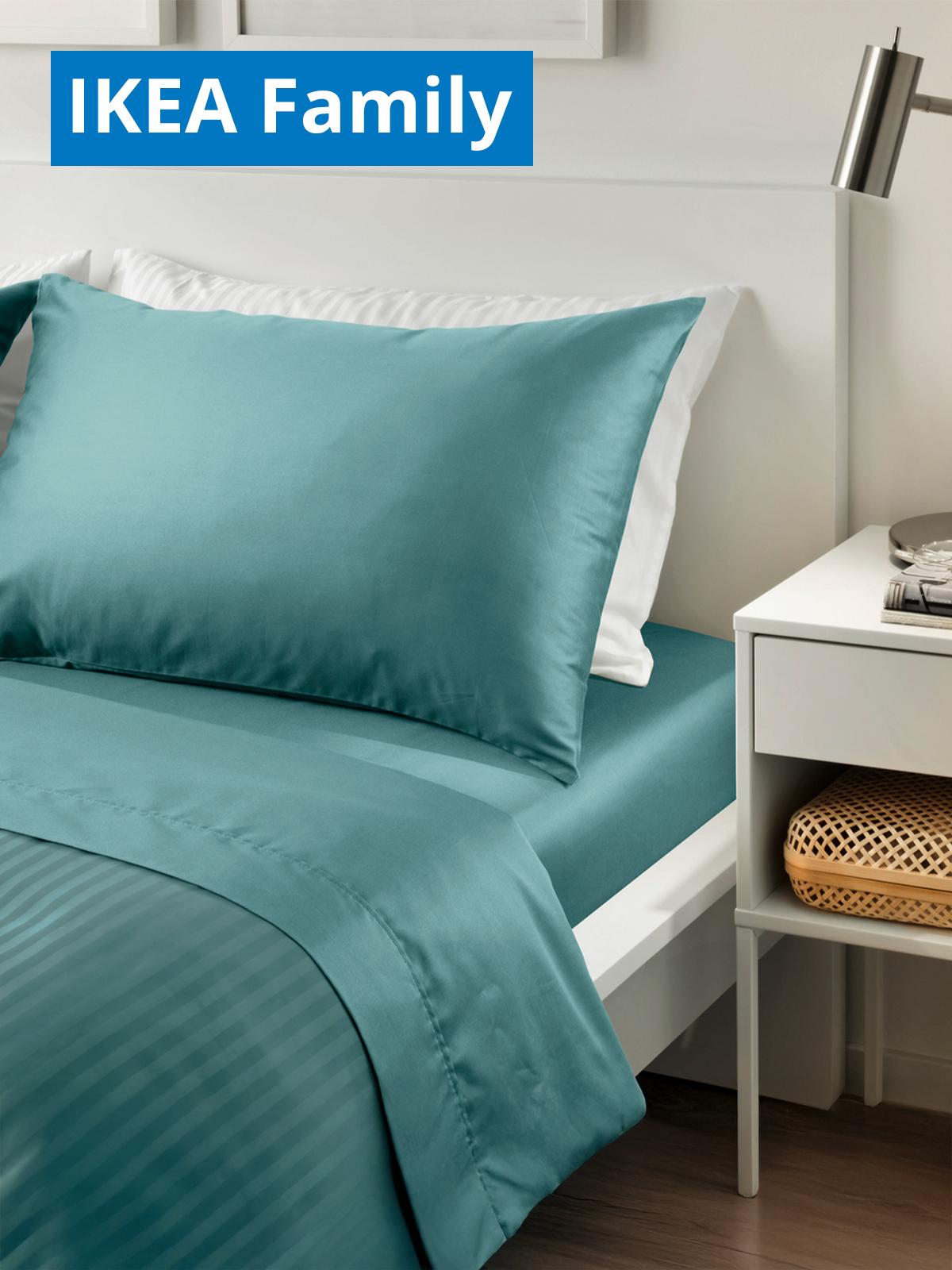 A bedroom room setting showcasing a blue-green NATTJASMIN bedsheet, pillowcase and duvet cover on a white MALM bed. On the top left corner, a blue tag with white text that reads "IKEA Family price".