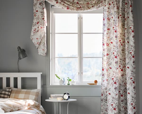 A bedroom window with floral curtains.