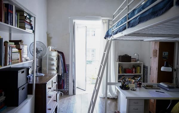 A bedroom with a loft bed, creating a studio feel that blends the needs of working and relaxing