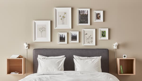 A bedroom with pictures above the bed