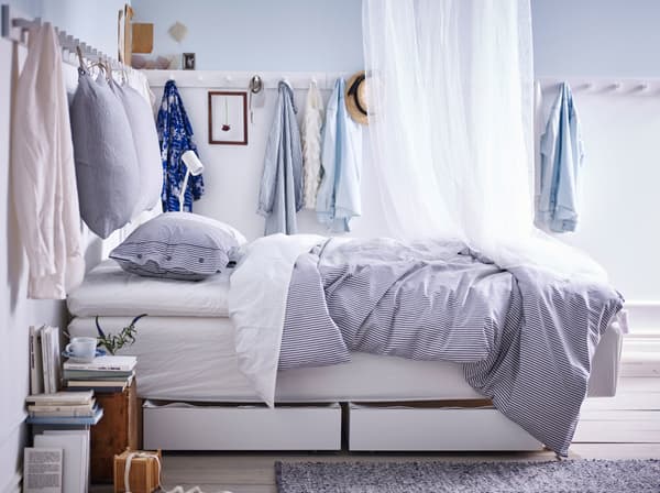 A bedroom with wall racks and hooks on all four walls