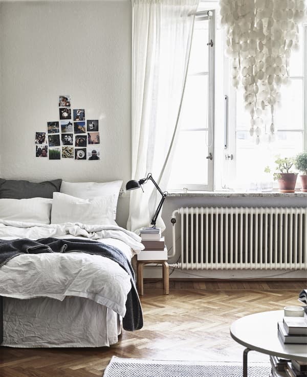 A bedroom with wooden floor and neutral decor.