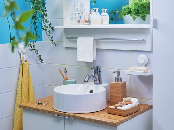 A beige and grey bathroom with RÅGRUND bamboo wash basin, bamboo corner shelf and bamboo shelving unit.