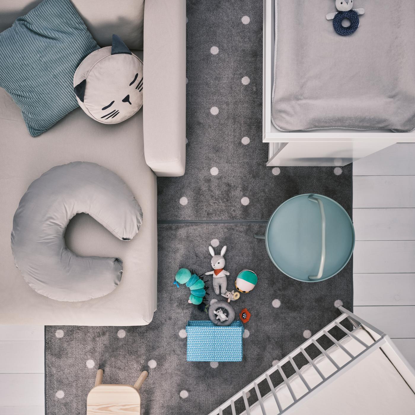 A beige chaise longue with cushions, a white SMÅGÖRA changing table and cot, plus a FLISAT children’s stool on a grey rug.