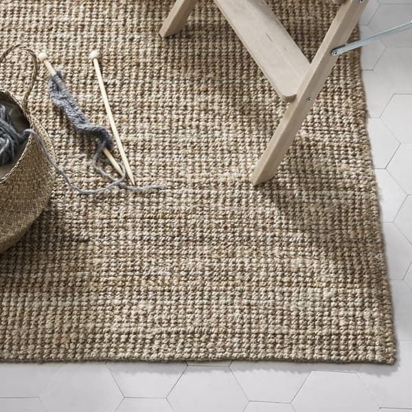 A beige LOHALS rug with a stool and knitting basket on top
