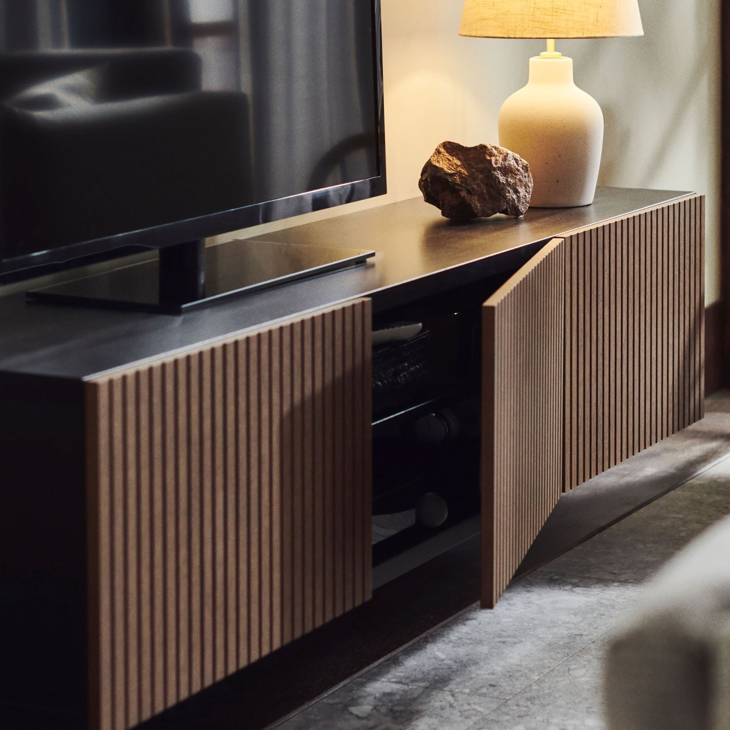 a-besta-tv-cabinet-with-brown-doors-with-a-tv-and-a-table-la-a50b15c5e44e190e5e18927bdd2608cc.jpg?f=sg