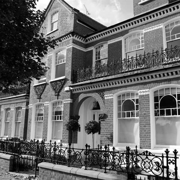A black and white photo of the exterior of a townhouse.