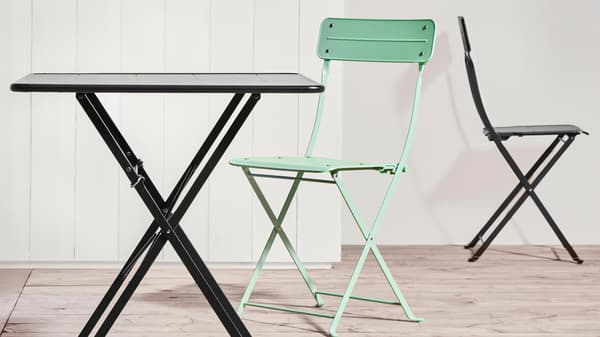 A black SUNDSÖ table and a light green SUNDSÖ folding chair.
