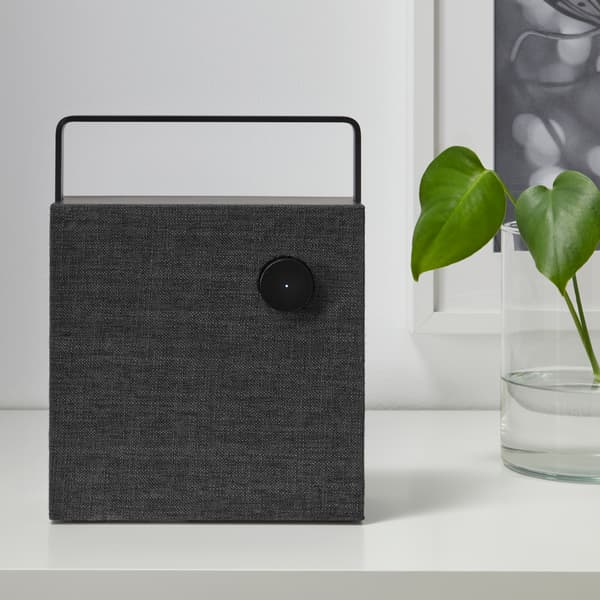 A black VAPPEBY speaker with plants and wall frame in the background.
