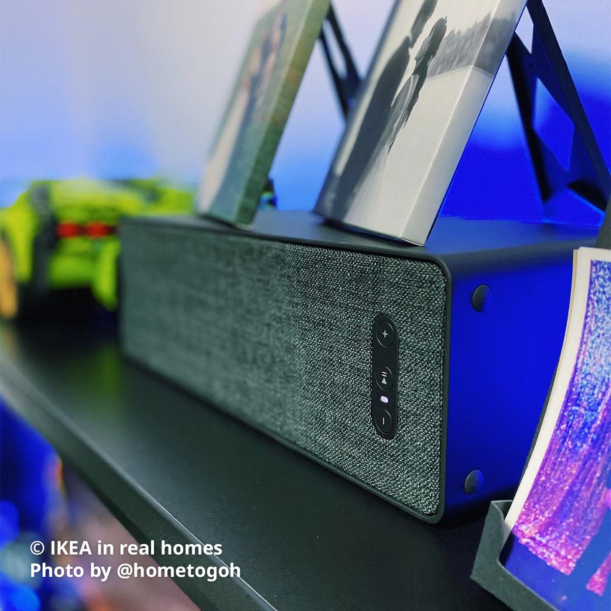 A black WiFi SYMFONISK bookshelf speaker being placed on a black FREDDE gaming desk. Photo by instagrammer @hometogoh from IKEA in real homes ©