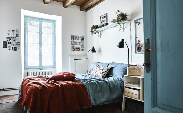 A blue and white bedroom, with a red bed cover.