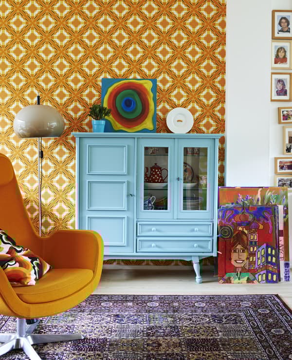 A blue cabinet against an orange wall.