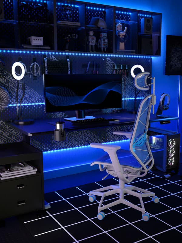 A blue IKEA STYRSPEL gaming chair in front of a black gaming desk in a neon lit room.