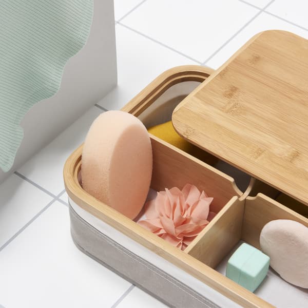 A box with lid partially removed showing compartments containing small sponges and accessories.