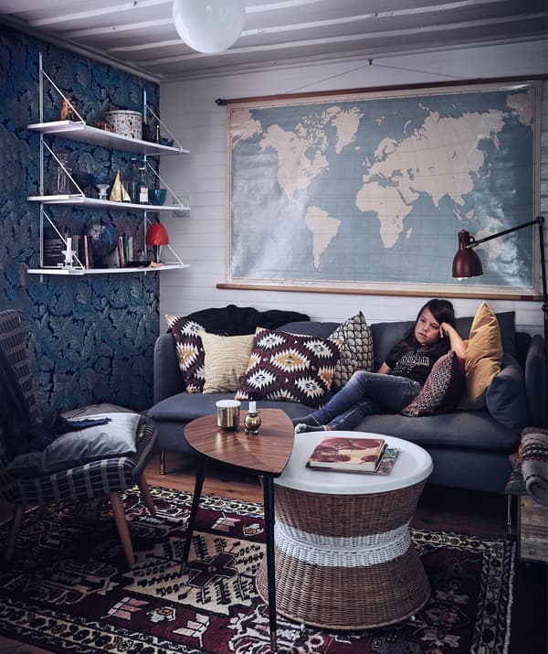 A boy on a sofa with side tables and task lighting.