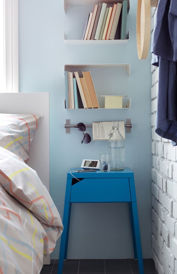 A bright blue bedside table in the bedroom