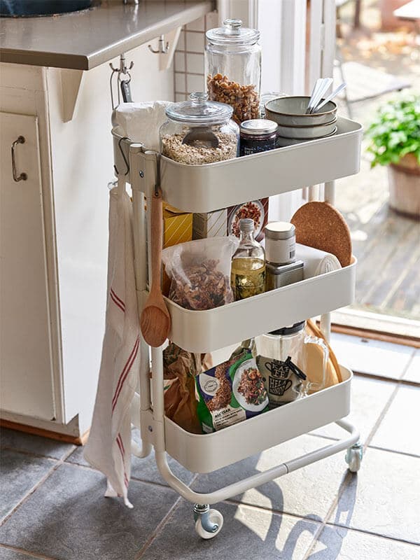 A bright kitchen featurng a fully loaded kitchen cart.