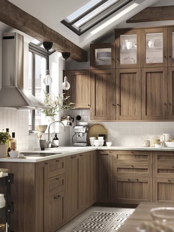 A bright white ENKÖPING kitchen with a subway tile backsplash and a plant sitting on the countertop.
