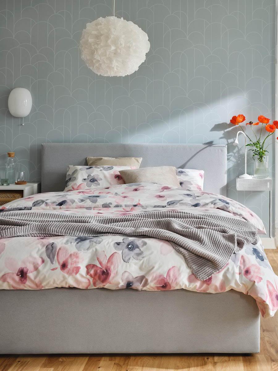 A brightly-lit bedroom with a big bed in focus.